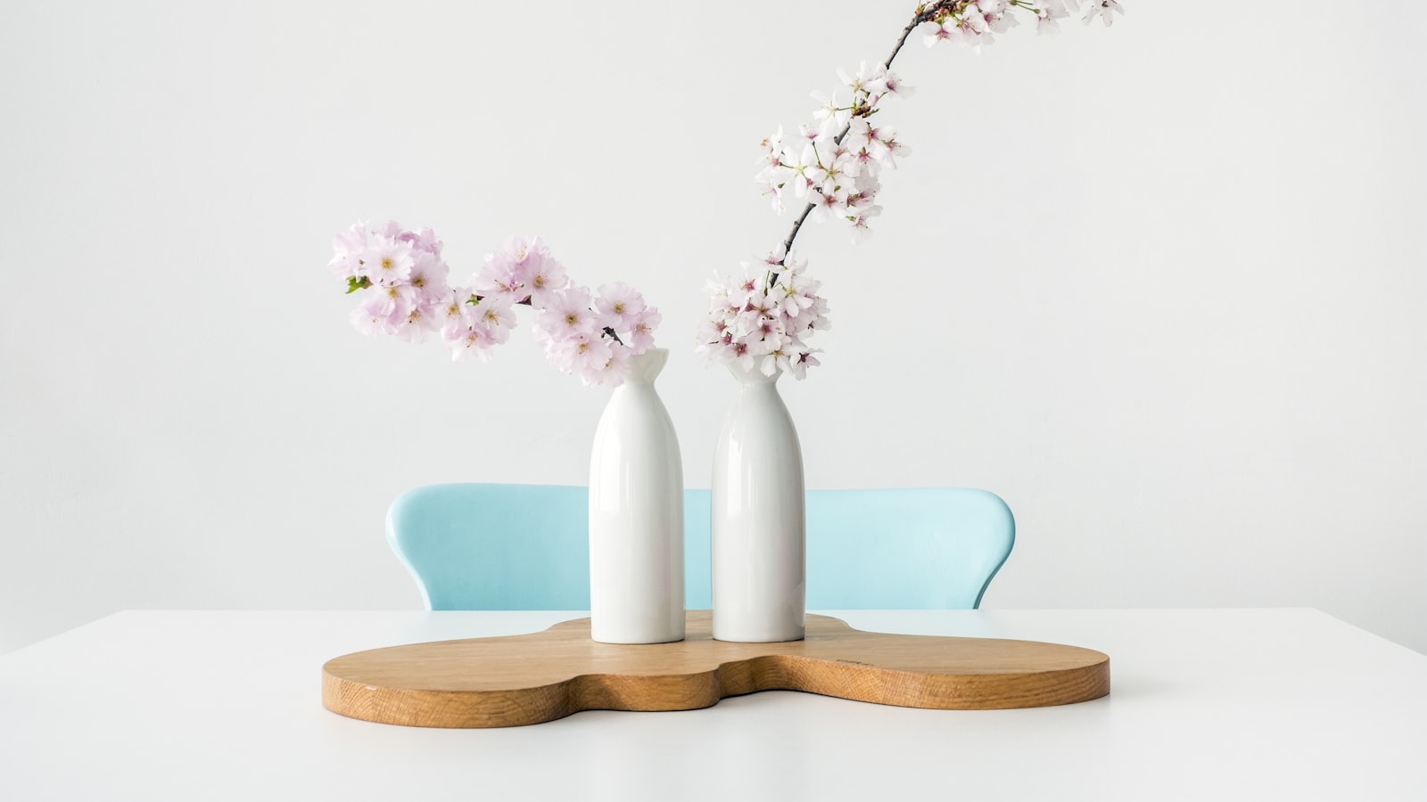 Balls of brightly colored homemade playdough on a wooden board beside a small rolling pin